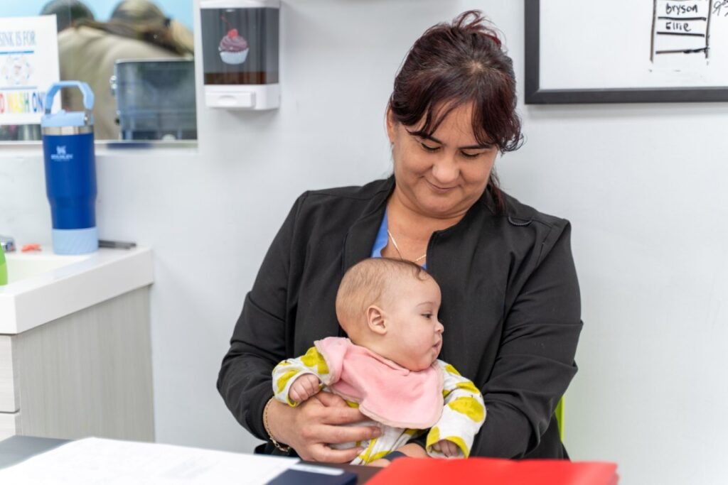 A Little Giants PPEC staff member holding an infant at the front desk in Tampa