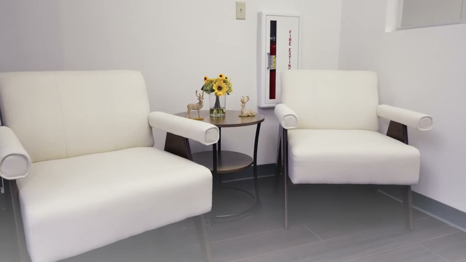 The family waiting area at Little Giants PPEC in Tampa, with white armchairs and a small side table