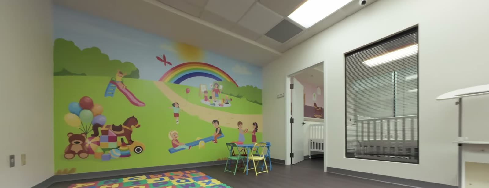 Bright Little Giants playroom in Tampa with activity tables and large windows