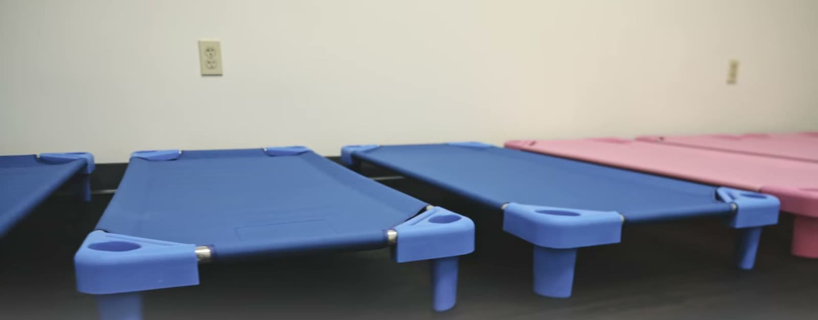 The rest area at Little Giants PPEC in Tampa, with blue and pink nap cots set out on the floor