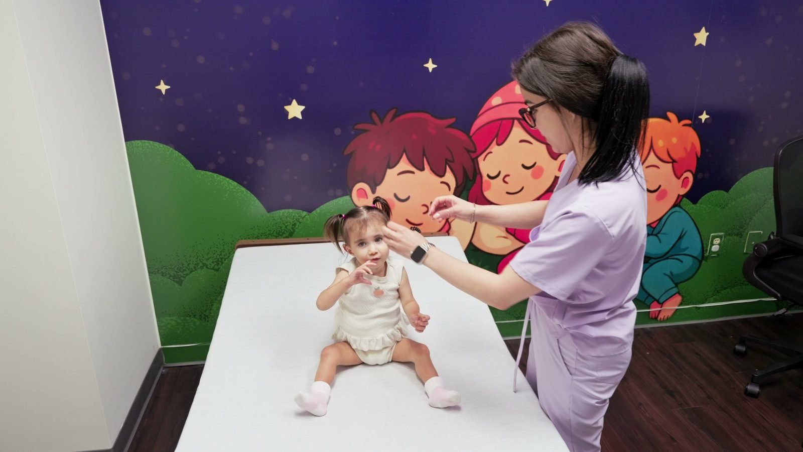 Nurse gently checking on a baby sitting up on a care bed at Little Giants PPEC in Tampa, FL