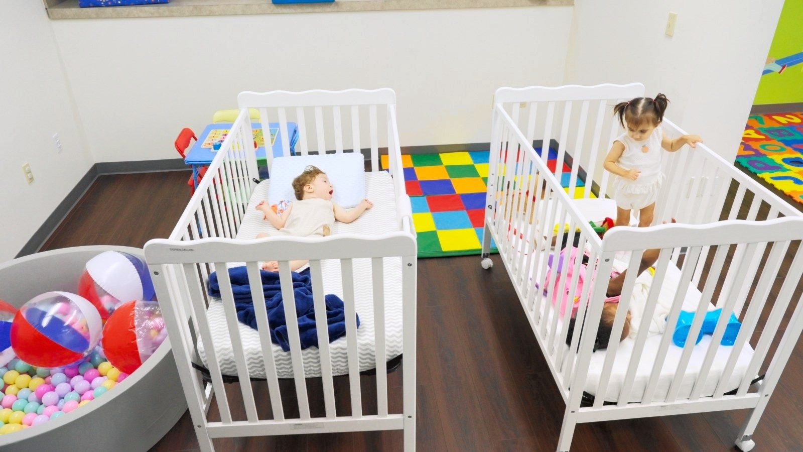 Two babies in white cribs in the bright nursery at Little Giants PPEC in Tampa, FL